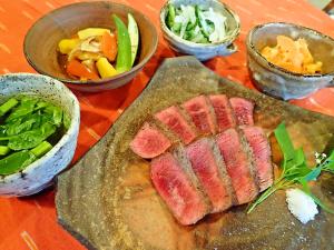 石垣岛纳塔海滩酒店的一张桌子,上面放着一盘肉和一碗蔬菜