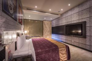 Jiuru欧阁汽车旅馆 - 屏东馆的一间卧室配有一张床和一台平面电视