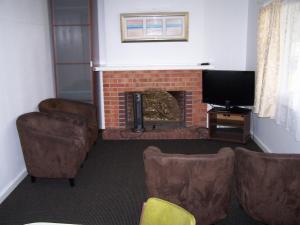 巴瑟尔顿热斯塔威尔汽车旅馆的客厅设有壁炉、椅子和电视