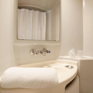 莱斯托雷特斯Première Classe Montélimar Nord的白色的浴室设有水槽和镜子