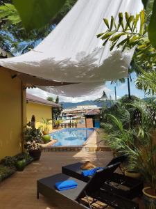 娘瑞塔纳卡茵莱酒店的一个带游泳池和白色遮阳伞的庭院