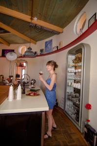 弗拉季莫夫Art Tower的站在厨房里拿着一杯葡萄酒的女人