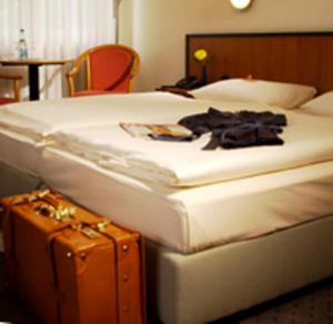 施韦特施彻韦德安德瑞森酒店的酒店客房,带一张床和行李箱
