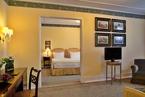里斯本艾薇达宫殿酒店的酒店客房,配有床和镜子