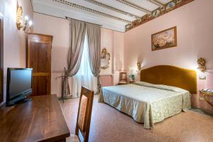 塞斯托拉瑟斯图拉圣马可酒店的一间卧室配有一张床、一张桌子和一台电视。