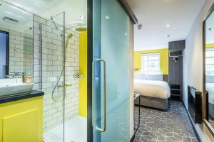 爱丁堡KM Hotel的带淋浴的浴室和客房内的一张床