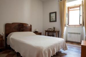 锡古恩萨普埃塔梅迪纳旅馆的一间设有白色床的卧室,位于一个窗户的房间