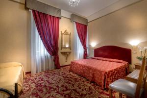 塞斯托拉瑟斯图拉圣马可酒店的酒店客房设有红色的床和窗户。