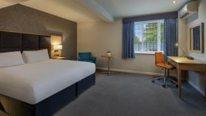 欣克利经典英国斯科奇利农庄酒店的配有一张床、一张书桌和一扇窗户的酒店客房