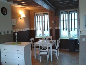 翁弗勒尔A la Terrasse coeur Honfleur的一间带桌椅和窗户的用餐室