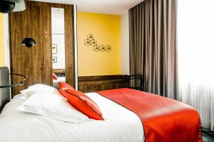 第戎红帽子酒店的一间卧室配有一张带红色枕头的床
