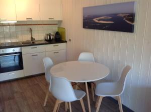阿雷斯Appart & p'tit Jardin的厨房配有桌椅和水槽。