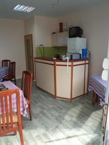 斯科普里乡村汽车旅馆的厨房配有带椅子的柜台和冰箱。