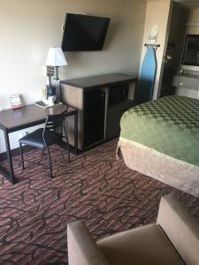 西门罗西门罗美国最有价值旅馆的酒店客房配有一张床、一张书桌和一张书桌。