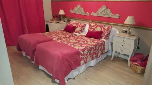 ÁgredaEl Encanto del Moncayo的一间卧室设有两张床和红色的墙壁