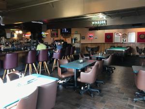 科迪亚克Shelikof Lodge的一间带桌椅的餐厅和一间酒吧
