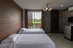坤西育府纳瓦度假酒店的酒店客房设有三张床和窗户。