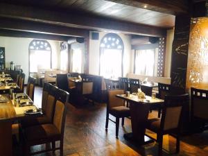 班加罗尔Hotel Ramanashree Richmond的用餐室设有桌椅和窗户。