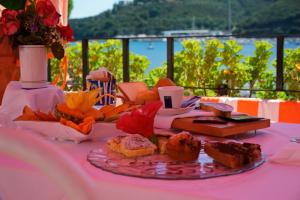 阿祖罗港卡拉迪莫拉酒店的一张桌子,上面有盘子的食物放在粉红色的桌子上