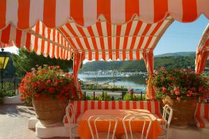阿祖罗港卡拉迪莫拉酒店的橙色和白色遮阳伞下的桌椅