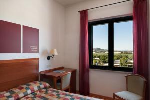 雷卡纳蒂港Hotel Brigantino Non Dista的酒店客房设有床和窗户。