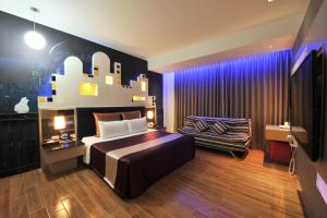 新竹新竹-紫晶彩绘汽车旅馆的一间卧室配有一张大床和一把椅子
