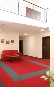 ÚjezdPenzion U Kostela的客厅配有红色沙发和红地毯