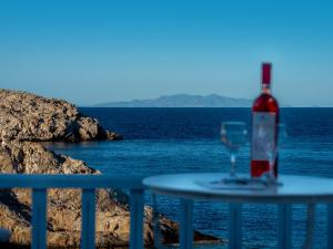 卡拉沃斯塔西Vardia Bay Studios的坐在海边的桌子上,一瓶葡萄酒