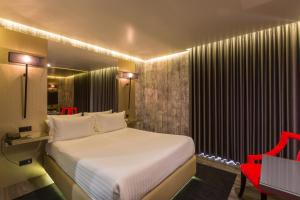 加亚新城特洛皮卡纳汽车旅馆的卧室配有白色的床和红色椅子