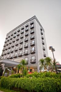 雅加达雅加达金卡莲萨马拉酒店的一座高大的白色建筑,前面有棕榈树