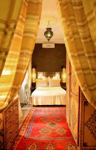 马拉喀什里亚德迪恩曼那摩洛哥传统庭院住宅的一间卧室配有一张床和红色地毯