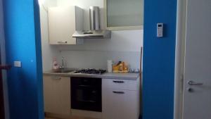 恩佩多克莱港Baciati Dal Sole的厨房配有白色橱柜和炉灶烤箱。