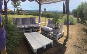 奥维多奥尔维耶托丘二号农场假日酒店的凉亭下配有两把椅子和一张野餐桌