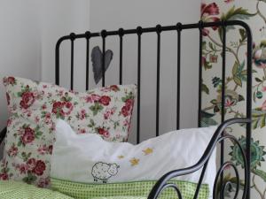 巴特乌拉赫Gästehaus 26/2的一张带花卉枕头和黑色栏杆的婴儿床