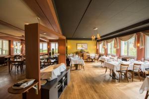 Hertenstein诺伊豪斯餐厅酒店的一间设有白色桌椅的用餐室