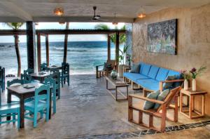 圣奥古斯蒂尼罗Casa Bagus的客厅配有蓝色的沙发和桌子,享有海景。