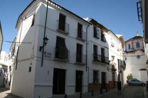 普里埃格·德·科尔多巴Casa Rural Villalta的白色的建筑,街道上设有黑色的门窗