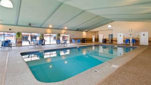 基恩基恩贝斯特韦斯特PLUS酒店的一个带蓝色桌椅的大型游泳池