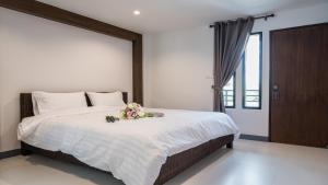 Ban Pa Sang (1)埃朵伊酒店的一间卧室配有一张带鲜花的大床
