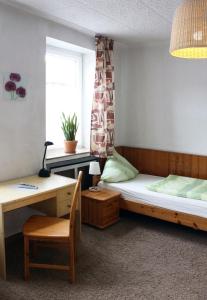 帕德博恩南部酒店的小房间设有一张床、一张桌子和一张书桌