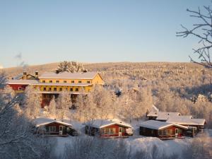 布鲁克斯瓦拉那Hotell Bruksvallsliden的雪中的房子,有雪盖屋顶