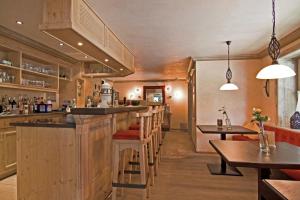 巴特欣德朗阿内里斯酒店的餐厅内的酒吧,配有木柜和桌子