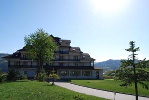 古拉哈莫卢洛伊托卡贝勒芙酒店的一座大房子,位于一座小山上,设有绿色草坪