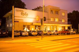 华沙Hotel Roko的夜间在停车场停车的酒店