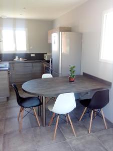 欧世La Petite Maison的厨房配有桌椅和冰箱。