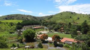 雅卡雷伊Hotel Fazenda Aldeia do Vale的山地田野里马的村庄