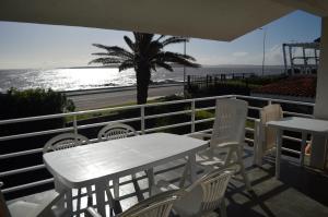 埃斯特角城Los Sargos的阳台上配有白色的桌椅,享有海景