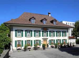 伯尔尼Romantik Hotel Landhaus Liebefeld的一座带绿色百叶窗的大型白色建筑