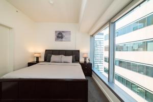 洛杉矶Luxurious Highrise 2b 2b Apartment Heart Of Downtown LA的一间卧室设有一张床和一个大窗户