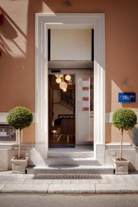 雷焦卡拉布里亚梅盯布鲁酒店的通往两座盆栽植物建筑的门道
